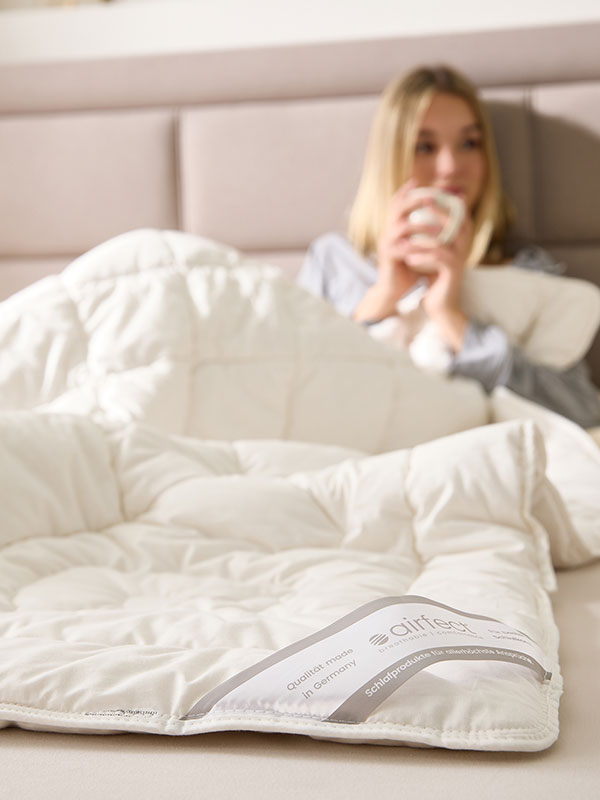 Frau unter airfect Comfort Decke