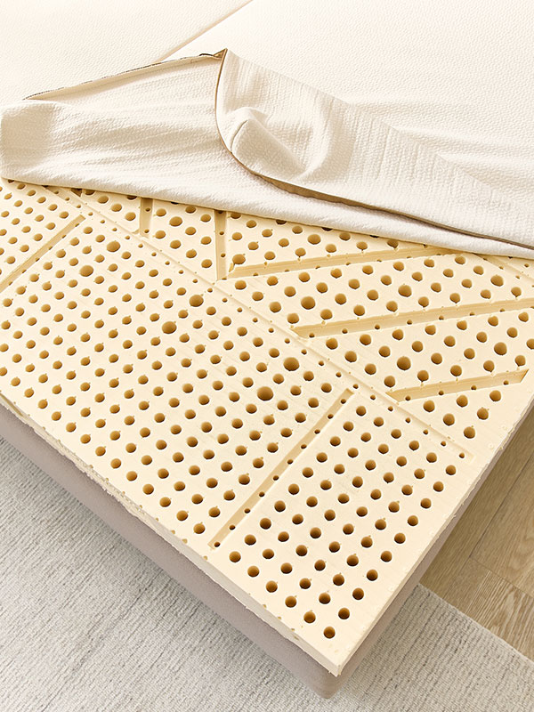 Frau drückt mit Händen auf Latexmatratze